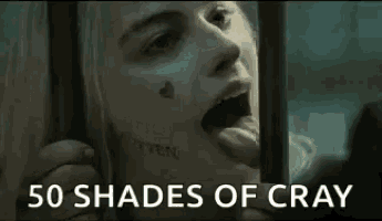 a close up of a woman behind bars with the words `` 50 shades of cray '' written on the bottom .