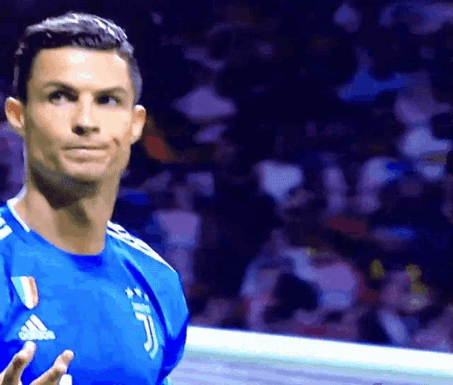a soccer player wearing a blue adidas jersey looks at the camera
