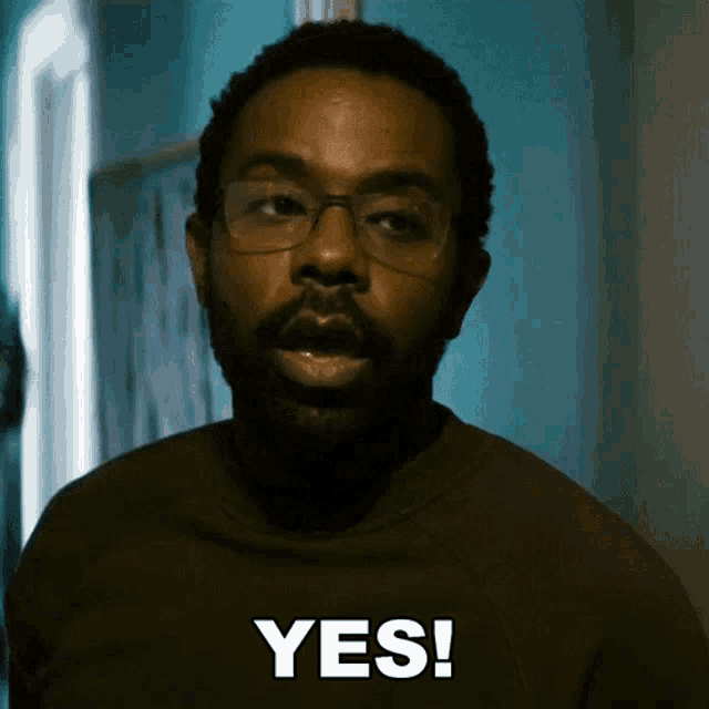 a man with glasses and a beard is saying " yes "