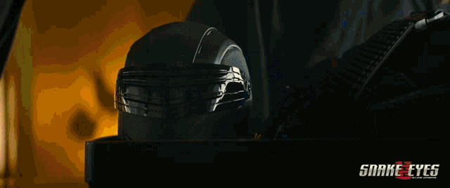 a close up of a person wearing a helmet with snake eyes written on the bottom