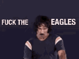 a man with a mustache is giving the middle finger and the words fuck the eagles are above him