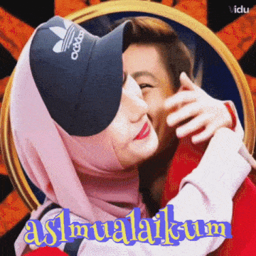 a woman wearing a hijab kisses a man wearing an adidas cap