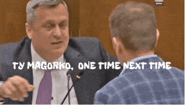 a man in a suit and tie talking to another man with the words ty magorko one time next time on the bottom