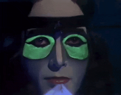 a close up of a woman 's face with glow in the dark eye patches .