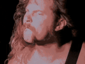 a close up of a man 's face with long hair and a beard .