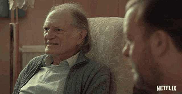 an older man sitting in a chair with the word gay written on the bottom