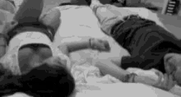 a man and a woman are laying on a bed with their legs crossed .