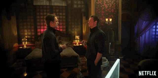 two men are standing in a room with a netflix logo on the bottom