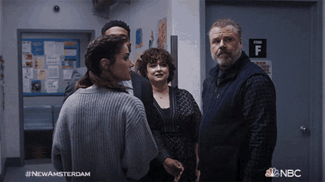 a group of people are standing in a hallway with a sign that says stair f