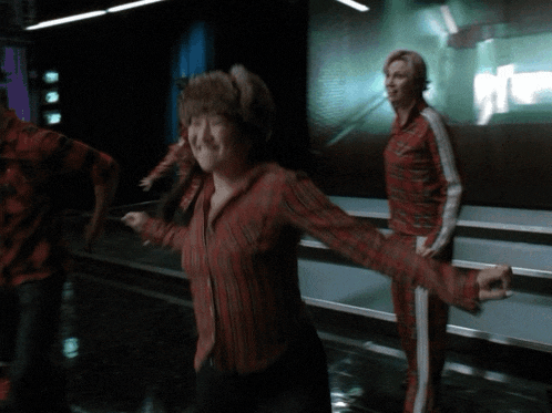 a woman in a red striped shirt is dancing