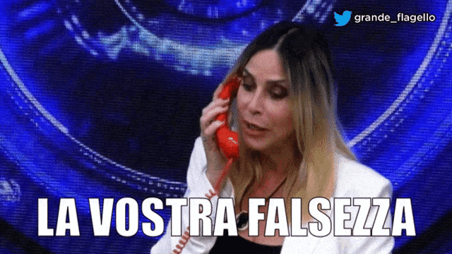 a woman is talking on a red telephone with the words la vostra falsezza written below her