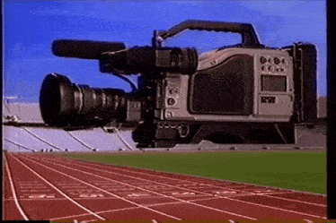 a video camera is recording a track and field event in a stadium