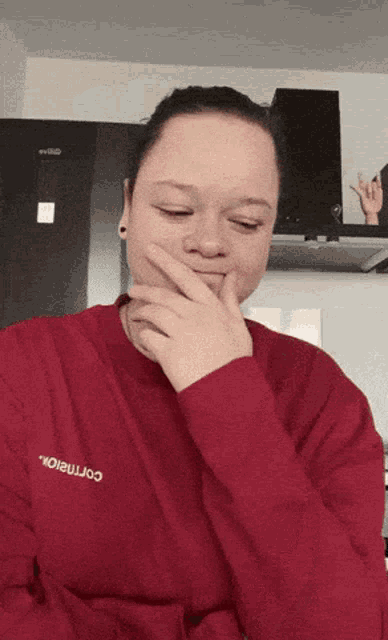 a woman wearing a red sweatshirt with the word cornalox on it