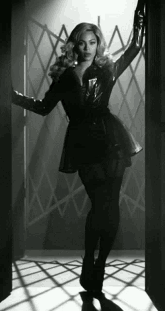 a black and white photo of a woman wearing a black coat