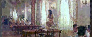 a woman is sitting on a table in a restaurant while people sit at tables .