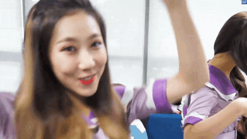 a girl in a purple uniform is smiling and looking at the camera .