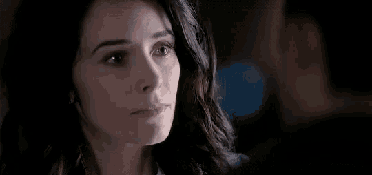 a close up of a woman 's face with a man behind her .
