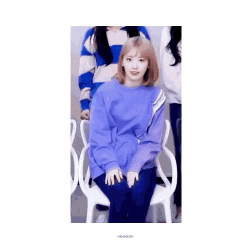 a woman in a purple sweater is sitting in a chair with her mouth open