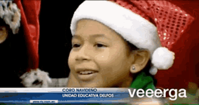 a little girl wearing a santa hat is on a news channel