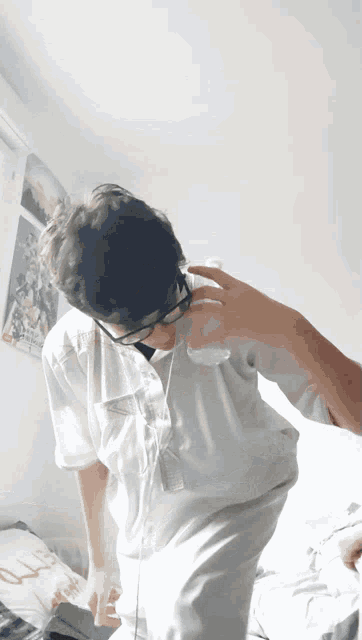 a man wearing glasses and a white shirt is standing in a room with a poster on the wall that says u.s.