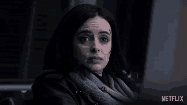 a close up of a woman with a scarf around her neck and a netflix logo behind her