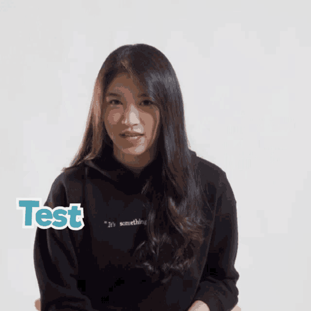 a girl wearing a black sweatshirt with the words test written on it