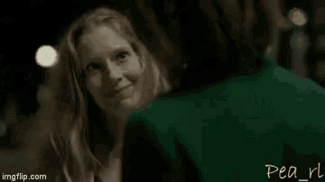 a man and a woman are kissing in a dark room in a movie .