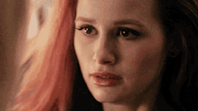 a close up of a woman 's face with a sad look on her face .