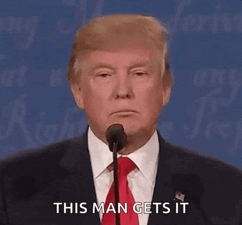 donald trump is giving a speech at a debate while wearing a suit and tie .
