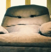 a couch with a face on it is sitting in front of a window .