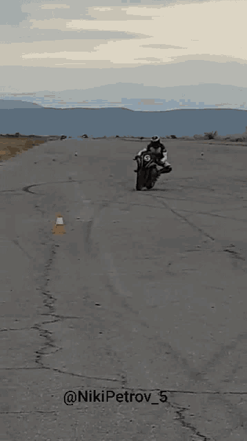 a group of people are standing around a motorcycle that has a number 5 on it .