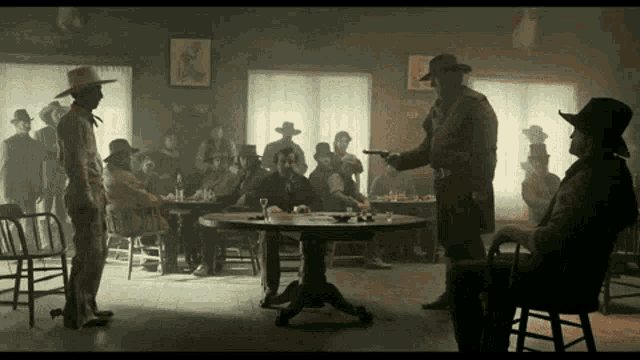 a group of men are sitting around a table in a room