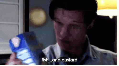 a man is holding a box of fish and custard in his hands .