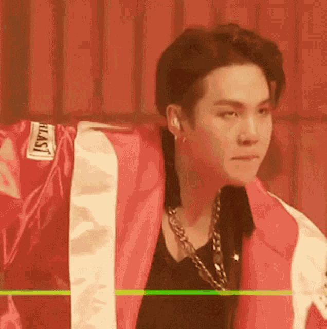 a close up of a person wearing a red and white jacket and a black shirt .