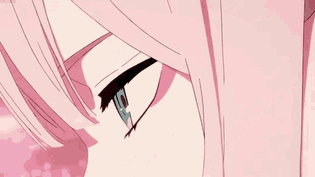 a close up of a person 's eye with pink hair and blue eyes .