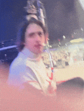a blurry picture of a man sitting in front of a crowd