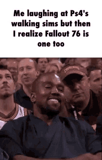 a man is laughing while sitting in a crowd of people .
