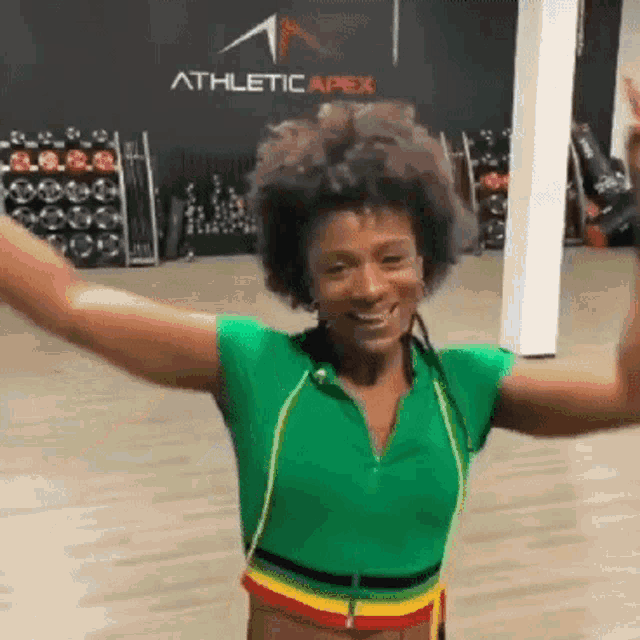 a woman with her arms outstretched in front of a sign for athletic apex