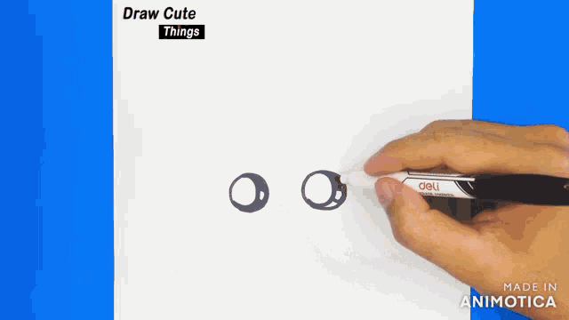 a person is drawing a pair of eyes with a marker that says deli