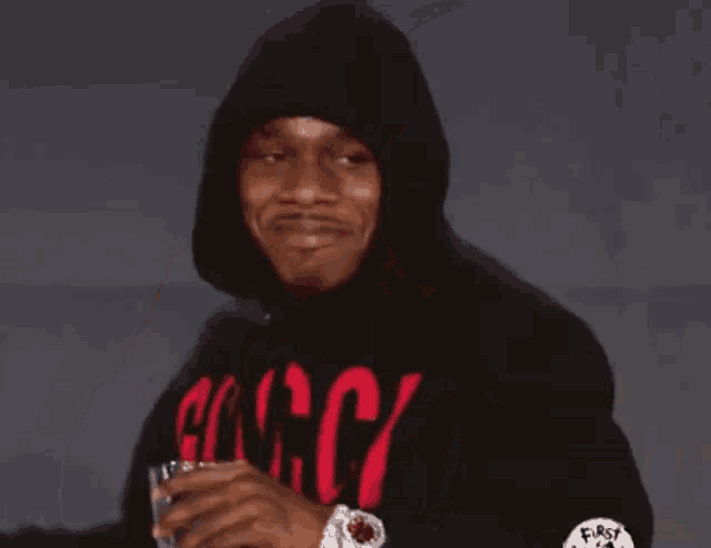 a man wearing a black hoodie with a red gucci logo on it