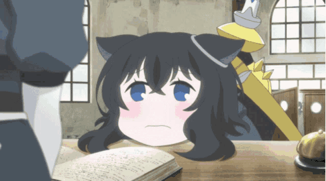 a girl with a cat ear is sitting at a table with a book on it
