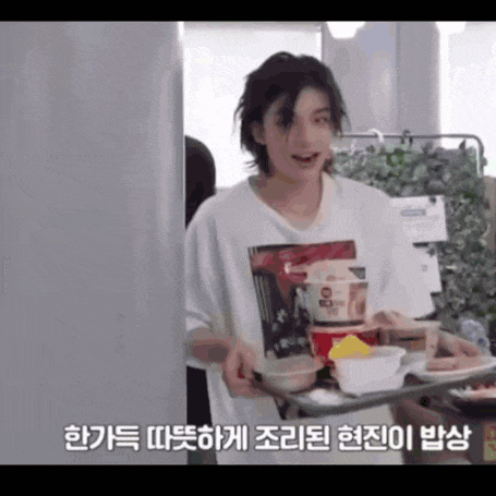 a young man is carrying a tray of food in a room .