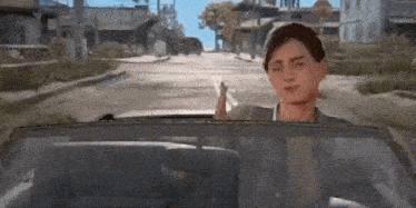a man is sitting in the driver 's seat of a car on a city street .