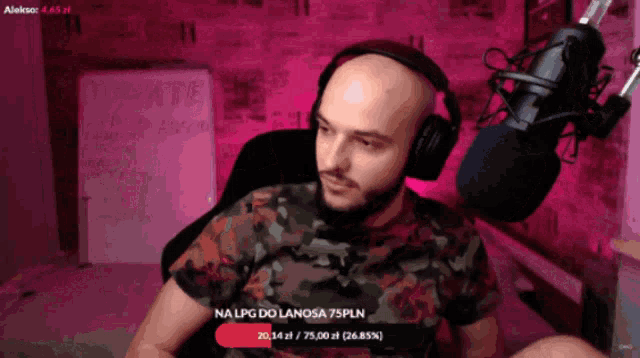 a man wearing headphones is sitting in front of a microphone and a sign that says tomate