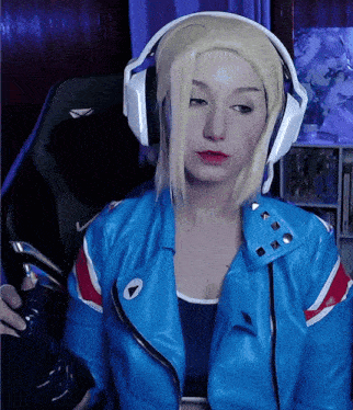 a woman wearing headphones and a blue jacket with a play button on it