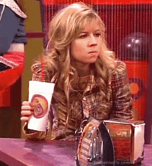 a woman sitting at a table holding a cup that says ' justienne ' on it