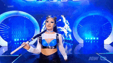 a woman is standing on a stage holding a bat .