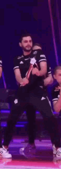 a group of men are standing on a stage dancing .