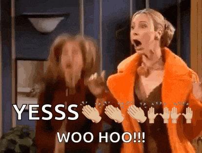 a woman in an orange coat is standing next to another woman who is clapping her hands .