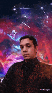 a man stands in front of a painting of a galaxy with the word movepic on the bottom